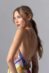 Vestido corto con estampado multicolor, escote halter con cadena dorada y espalda descubierta.