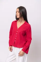 Camisa roja simil lino, de corte recto, con cuello camisero y cierre frontal con botones.
