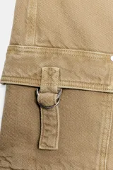 Falda pantalón cruzada de tiro medio en color tostado, con diseño estilo cargo que incluye bolsillos de parche con solapa y detalle de argolla metálica. Cuenta con trabillas y un cinturón integrado con hebilla metálica.