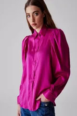 Camisa fucsia de seda con mangas abullonadas y cuello clásico.