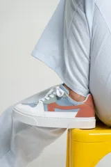 Zapatillas bajas color beige y marrón, con cordones y suela blanca.