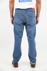 Pantalón jean de corte recto clásico con cinco bolsillos, botones de cobre y costuras color camel.