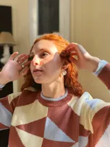 Sweater de punto con diseño geométrico en tonos celeste, marrón y beige.