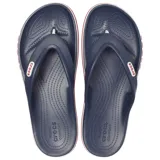 Ojotas Crocs Bayaband Flip de color azul marino, con tiras de dedo y suela con banda lateral blanca y roja con la inscripción de la marca en relieve.