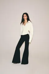 Top de tejido combinado color blanco, con cuello solapa, escote en V y cierre frontal con botones. Presenta mangas largas con puños anchos.