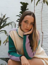 Buzo tejido de punto color crema con cuello alto y mangas largas con rayas horizontales en verde y lila.