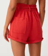 Short clochard de viscolino color beige, con cintura alta elastizada, bolsillos grandes aplicados en los laterales y detalle de cinturón de cuerda con borla.