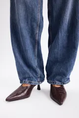 Zapato destalonado de cuero vacuno con textura de reptil, punta fina y tacón bajo tipo kitten heel.