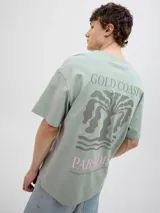 Camiseta verde con estampado de palmera, olas y texto "Gold Coast Surfers Paradise".