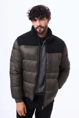 Campera puffer negra con paneles de textura tipo corderito en la parte superior del pecho y hombros. Cuenta con cierre frontal, puños y ruedo acanalados, y un bolsillo vertical con cierre en el pecho.