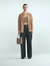 Cardigan de punto color tostado, con cuello camisero, cierre frontal de botones y mangas largas.