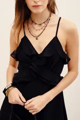 Vestido corto negro de viscosa georgette, con escote en V, breteles finos y volados decorativos en el frente.