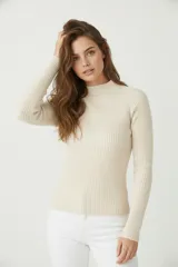 Polera de viscosa color beige claro, de tejido canalé, corte ajustado al cuerpo y cuello alto.