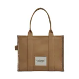 Cartera The Large Tote de Marc Jacobs en color tostado, con diseño estructurado y asas superiores resistentes. Cuenta con el estampado característico 'THE TOTE BAG MARC JACOBS' en la parte frontal y un amplio compartimento interior.