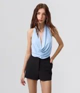 Micro short de sastrería negro, de tiro alto y corte ajustado, confeccionado en poliéster con elastano, con pretina ancha cruzada en el delantero.
