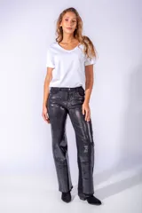 Pantalón de jean gris con apliques de lentejuelas plateadas en forma de cuadrícula.