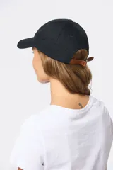 Gorro con visera de lona rosado con bordado frontal en tonos verde y violeta.