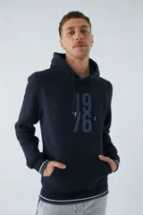 Buzo canguro azul marino con capucha ajustable, bolsillo canguro, fit regular, arte estampado en relieve, logo en goma y composición de 80% algodón y 20% poliéster.