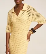 Vestido midi color amarillo pálido con efecto crochet, cuello polo, manga corta y abertura lateral. Confeccionado en algodón BCI más sostenible.