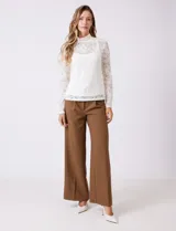 Blusa de encaje negro con cuello alto y mangas largas. Incluye musculosa interna a tono para mayor cobertura.