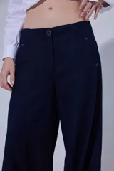 Pantalón de tiro medio y piernas anchas, confeccionado en mezcla de lino y algodón, con bolsillos delanteros y traseros con detalles de costuras pespunteadas a contratono.