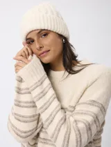 Sweater de tejido de punto en color beige con diseño de rayas horizontales en tono más oscuro. Presenta cuello redondo y mangas largas con puños ajustados.