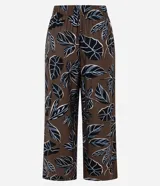 Pantalón tipo pantacourt de calce holgado y tiro alto, confeccionado en tejido de viscosa con estampa de follaje en tonos negro, blanco y azul sobre fondo marrón. Posee cintura elástica.