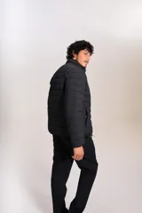 Campera acolchada negra con cierre frontal, cuello alto y diseño de costuras horizontales. Presenta un ajuste entallado y tejido exterior resistente al agua.