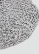 Gorro gris de punto calado, confeccionado en poliéster, con detalle de pequeños botones de nácar decorativos en el borde inferior.