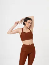 Top deportivo color marrón con breteles finos cruzados en la espalda.