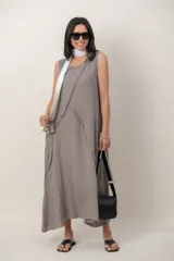 Vestido largo de lino color gris, sin mangas, con escote redondo y detalles de costuras con cortes desflecados al frente.