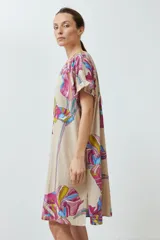 Vestido beige con estampado de flores de colores, corte recto y mangas cortas con volados.