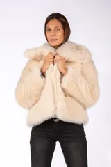 Tapado corto de piel sintética en color beige, con cuello amplio y solapas, de corte recto y mangas largas.