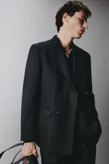 Blazer cruzado regular fit negro, con solapa de pico, bolsillos con solapa en la cadera, bolsillo de vivo en el pecho y cierre frontal con doble botonadura.