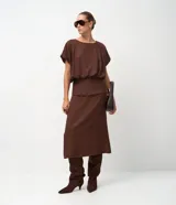 Pollera midi de viscosa color marrón, con diseño de canesú estructurado en la cintura que aporta una división visual y un ajuste definido.