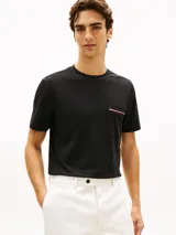Remera de manga corta color negro, de corte regular fit y cuello redondo. Cuenta con un bolsillo en el pecho adornado con una cinta distintiva de líneas roja, blanca y azul.