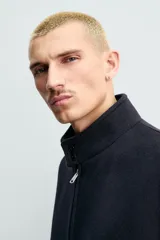 Cazadora de corte regular fit confeccionada en tejido de mezcla de lana y cashmere. Presenta cuello subido con cierre de botones, cierre frontal con cremallera de doble dirección, bolsillos laterales de vivo y acabados en rib de punto en puños y cintura.