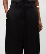 Pantalón wide leg de corte sastrero confeccionado en tejido satinado con caída fluida. Presenta cintura con presillas, cierre frontal oculto y diseño de piernas amplias.