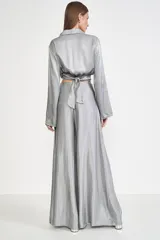 Camisa gris de satén con corte cropped, cuello clásico, mangas largas abullonadas y cierre cruzado con lazo.