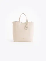 Cartera tipo tote bag pequeña de cuero vacuno negro con diseño de abejas grabadas en bajo relieve. Cuenta con doble asa de mano, correa ajustable y un tag colgante con dije metálico en forma de abeja.