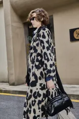 Tapado largo de poliéster con estampado animal print tipo leopardo, solapas amplias y cierre frontal cruzado con botones.