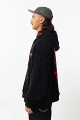 Buzo hoodie negro de algodón y poliéster con fit oversize. Estampa en la espalda con diseño de rosas pixeladas.