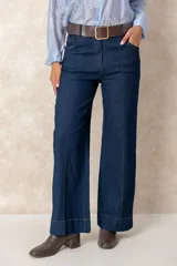 Pantalón de jean azul de corte ancho y tiro alto, con diseño de cinco bolsillos y costuras a la vista.