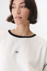 Remera de manga larga con corte oversized, color azul marino con cuello redondo en contraste color marrón. Presenta costuras decorativas a contratono hechas a mano en la zona de los hombros y logo bordado en el centro del pecho.