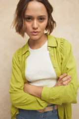 Camisa de manga larga color rosa con cuello clásico y frunces en los hombros.