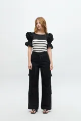 Pantalón cargo negro con bordado calado, tiro medio y corte recto.