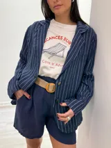 Short de lino color rojo, con cintura elástica y cinturón de rafia con hebilla circular.