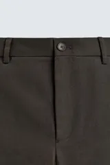 Pantalón de corte recto confeccionado en tejido compacto de algodón con estructura twill. Presenta cierre frontal con cremallera y botón, bolsillos laterales y bolsillos traseros de vivo con botón.