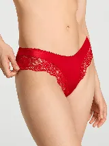 Bombacha tipo cheeky de tiro bajo y pierna alta, color rojo, confeccionada con detalles de encaje floral en los laterales y ribete superior delicado.