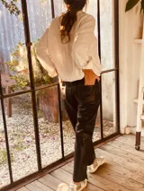 Pantalón negro de cuero ovino italiano, corte mom fit con tiro semi alto y tajos inferiores.